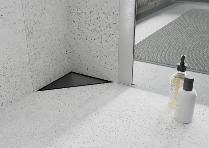 Schwarzer Bodenablauf im grauen Badezimmer