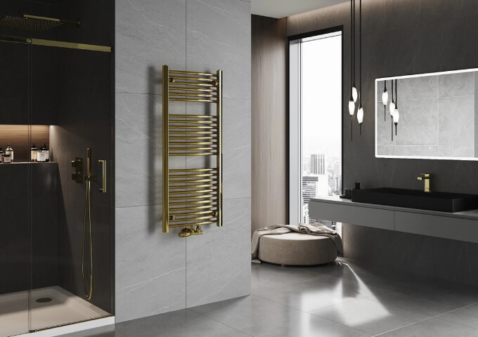 Goldener Heizkörper mit Thermostatkopf im Badezimmer